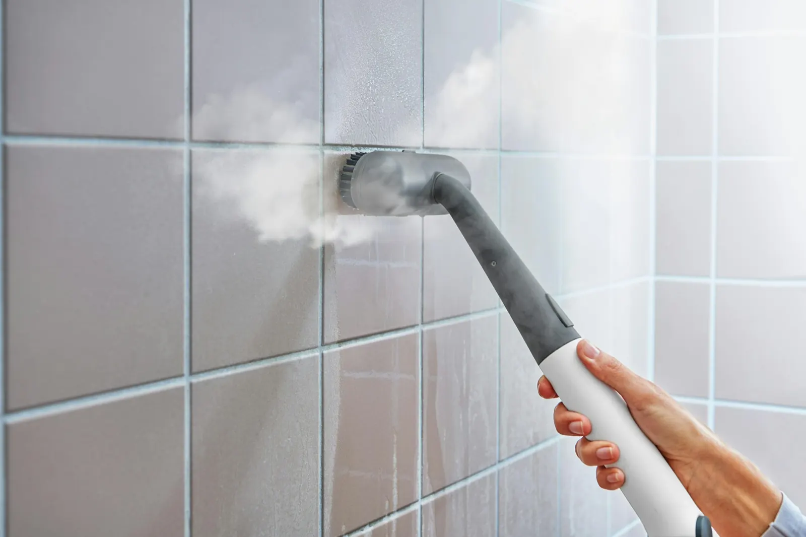 Buharlı temizlik makinesinin fırçalı başlığıyla banyo fayansları buharla temizleniyor